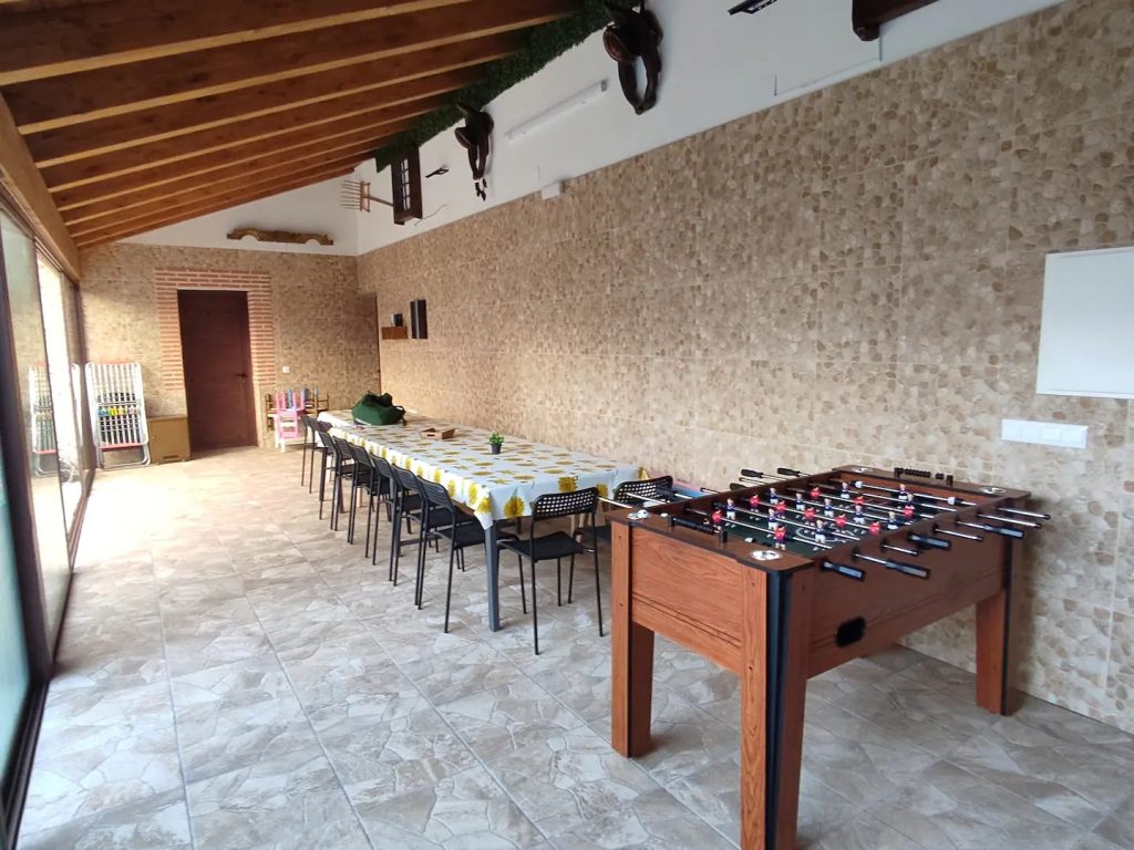 Patio cubierto con mesa para grupos y futbolín en Casa Rural Abuela Consuelo. Un espacio para compartir comidas, conversaciones y buenos momentos.